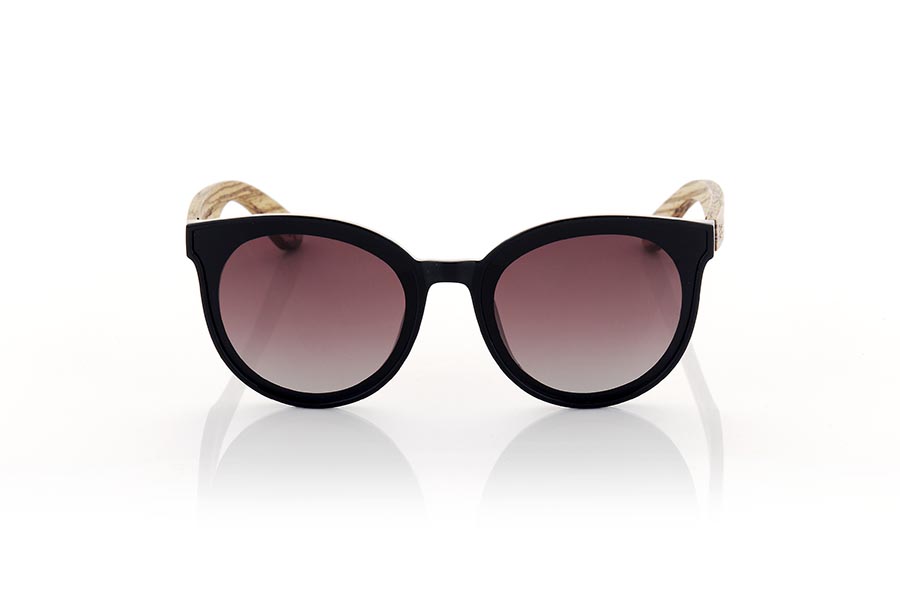 Wood eyewear of Walnut SOPHIA. Sophia sunglasses are the perfect accessory to add a touch of style to your looks at all times. With a rounded frame in satin black, the lenses are mounted on the frame, giving it a retro and modern touch at the same time. The wide temples in grained walnut make a harmonious contrast to the frame. This model is a very attractive female model, although some more daring men will also want to have one. It is available in two lens colors so you can choose the one that best suits your needs and style. Do not hesitate to get some Sophia glasses to protect your eyes from the sun with style. Front measurement approx: 142x55mm for Wholesale & Retail | Root Sunglasses® 